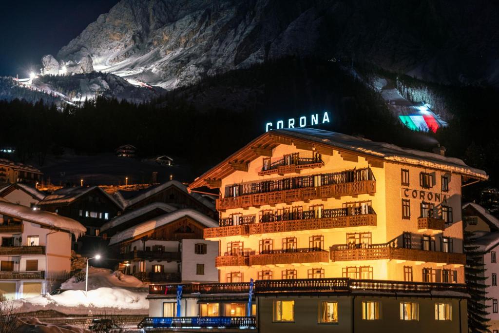 un hotel frente a una montaña por la noche en Hotel Corona, en Cortina dʼAmpezzo