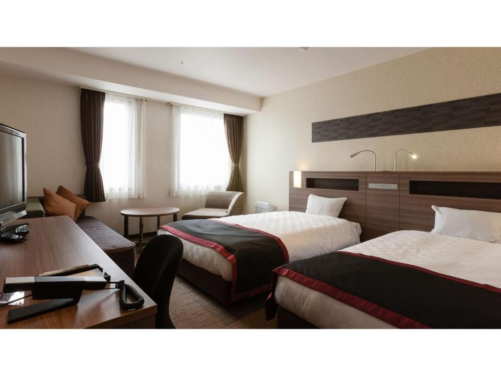 um quarto de hotel com duas camas e uma secretária em Onomichi Kokusai Hotel - Vacation STAY 87041v em Onomichi