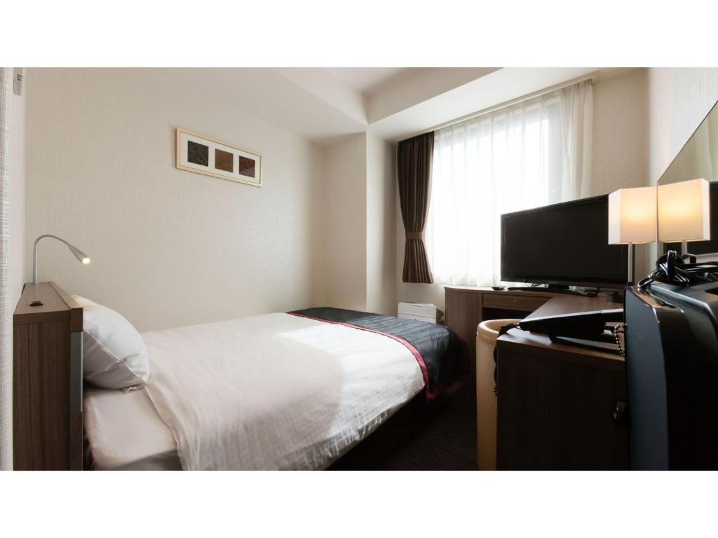尾道市にあるOnomichi Kokusai Hotel - Vacation STAY 87042vのベッドと薄型テレビがあるホテルの部屋