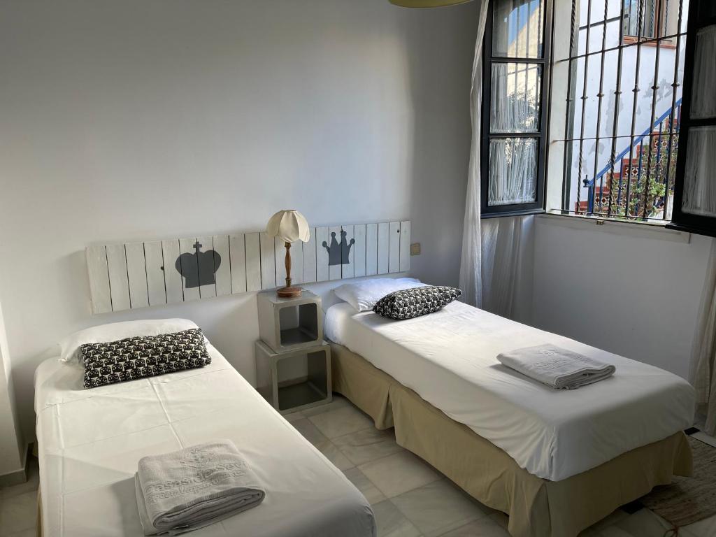 セビリアにあるCasas de Sevilla - Apartamento Puente de Trianaのベッドルーム1室(ベッド2台、窓付)