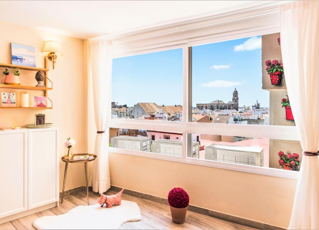a room with a large window with a view of the city at Malaga Centre Apartment with Parking in Málaga
