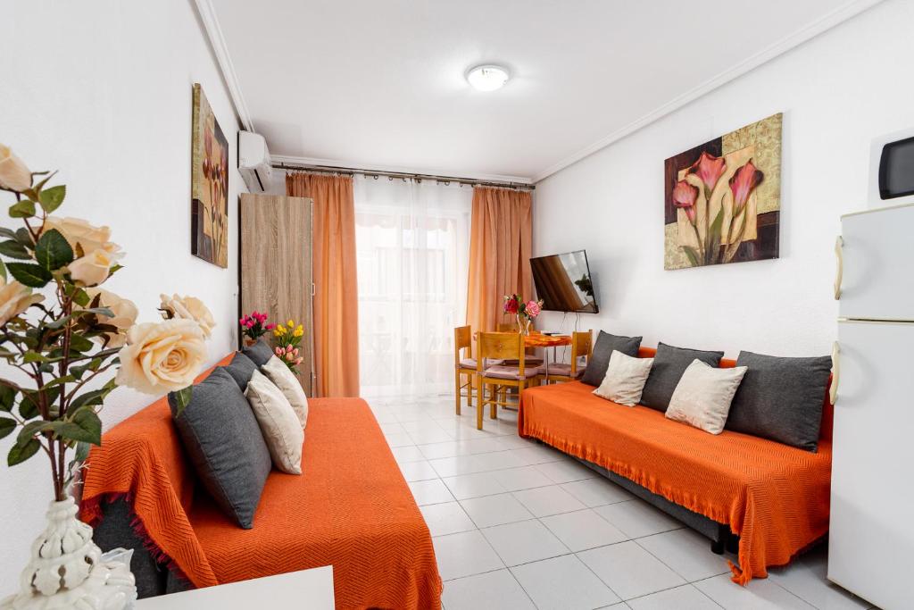 een woonkamer met twee oranje banken bij Apartment Studio Relax Almudena in Torrevieja
