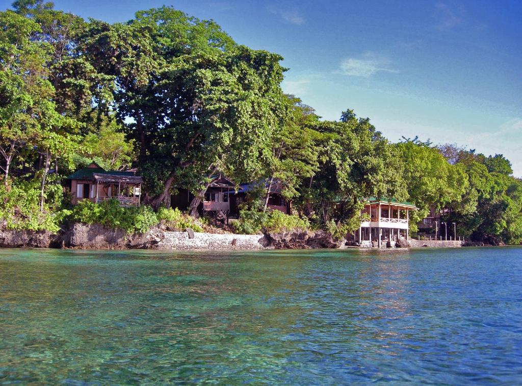 un groupe de maisons sur la rive d'une masse d'eau dans l'établissement Bunaken Divers Sea Breeze Resort, à Bunaken