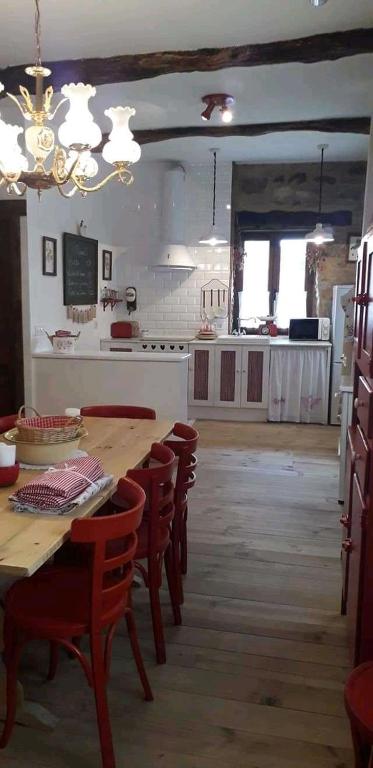 a room with a table and chairs and a kitchen at Casa rural Nica in Arganza