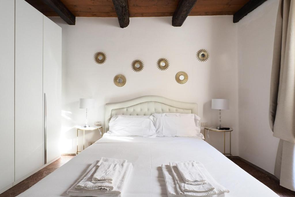 a bedroom with a white bed with two towels on it at Mila Apartments Magenta in Milan