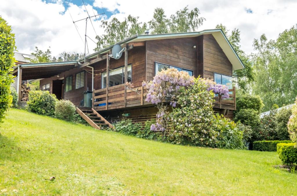 a wooden house on a hill with a yard at 34 Denby Place in Hanmer Springs