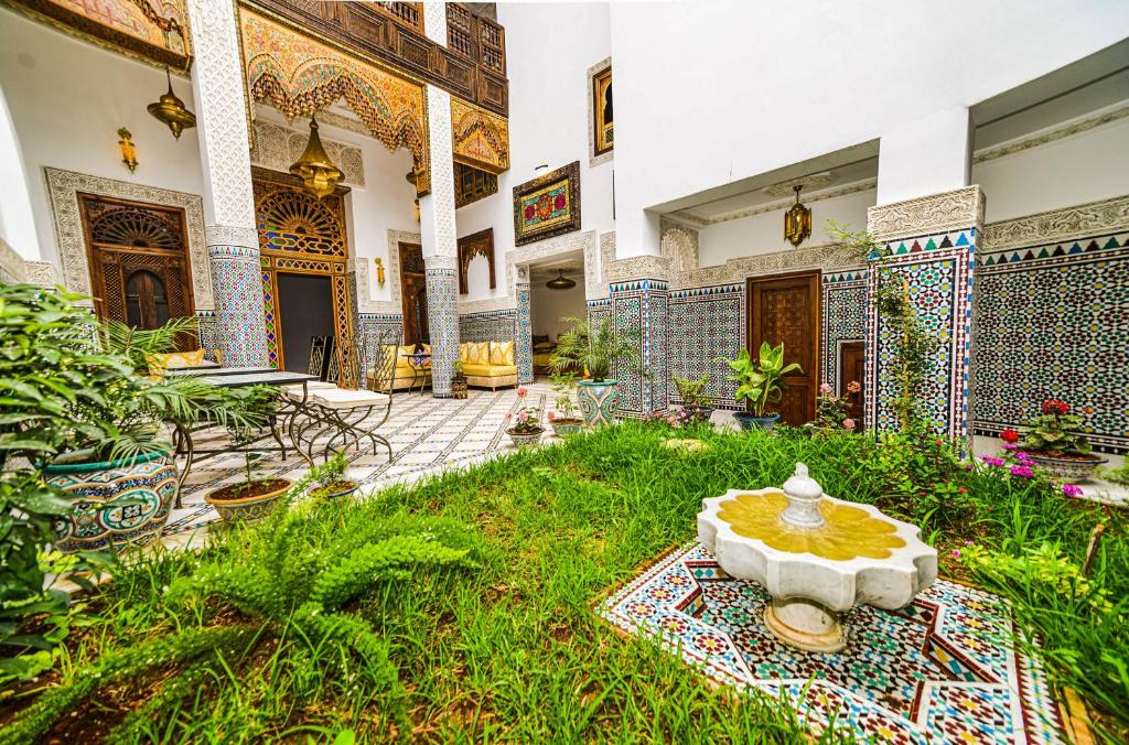 a courtyard with a fountain in the middle of a building at Riad Fez Mahal in Fès