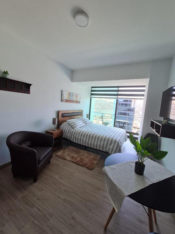 a bedroom with a bed and a chair and a table at Hermoso departamento estudio ubicación inmejorable in Antofagasta