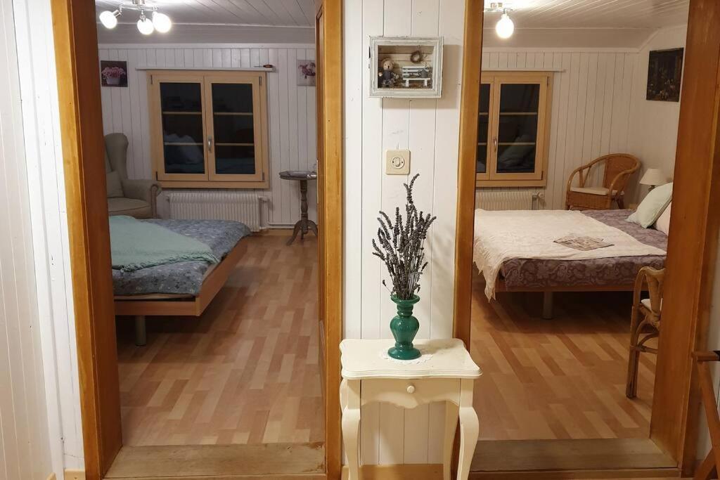 WHITE HOME IN AESCHI BEI SPIEZ في Aeschi bei Spiez: غرفة مع غرفة نوم مع سرير و مزهرية على طاولة