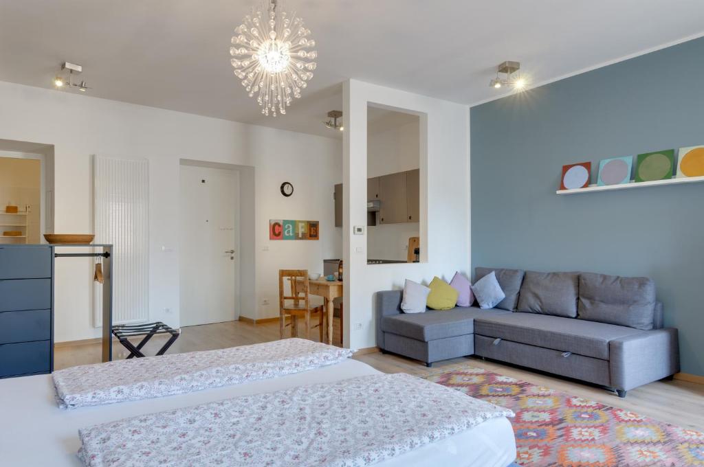 a living room with two beds and a couch at Sonnenuhr Bolzano Apartments in Bolzano