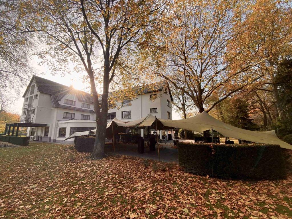 uma tenda em frente a uma casa com uma árvore em Hotel Mardaga em As