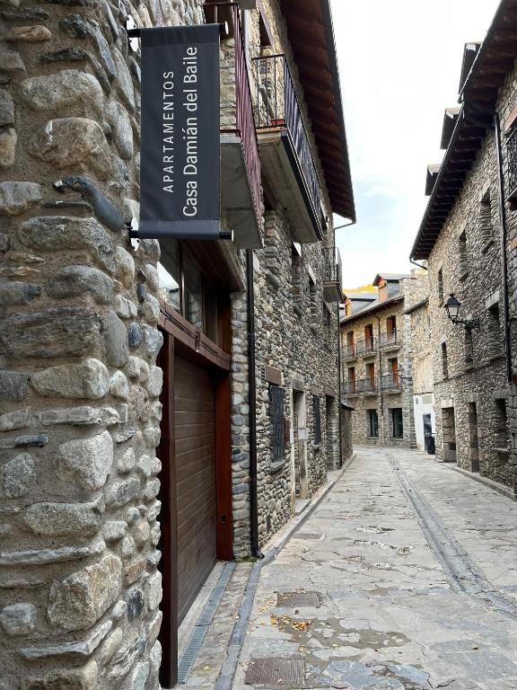 an alley with a sign on the side of a building at Casa Damián del Baile Apartamentos in Benasque