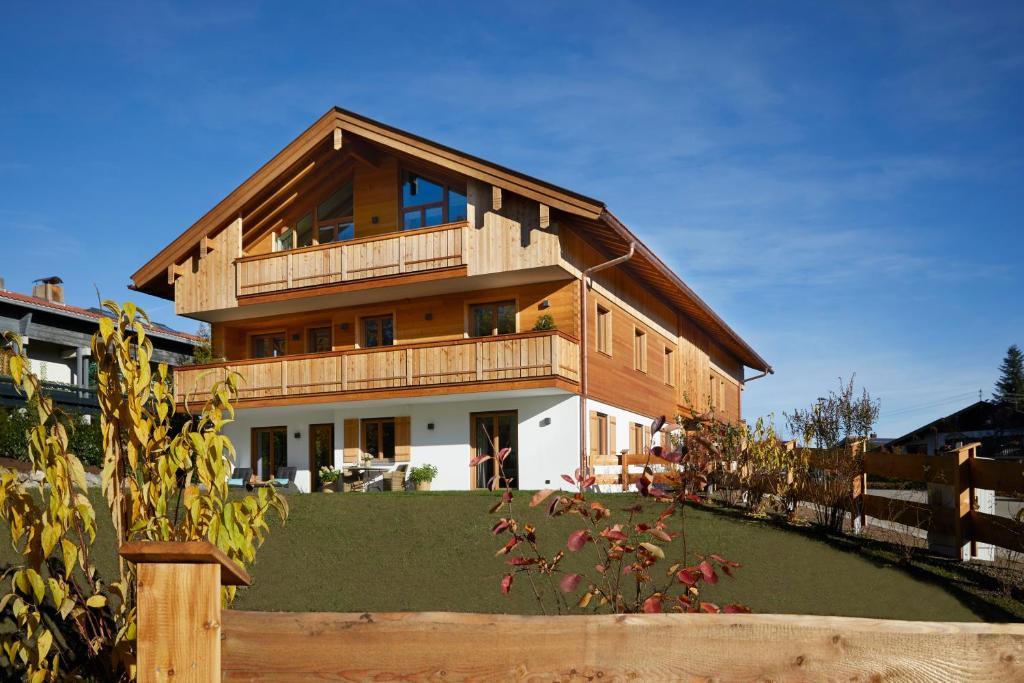 ein Holzhaus mit Balkon auf einem Hof in der Unterkunft Ansitz Brenner in Gmund am Tegernsee
