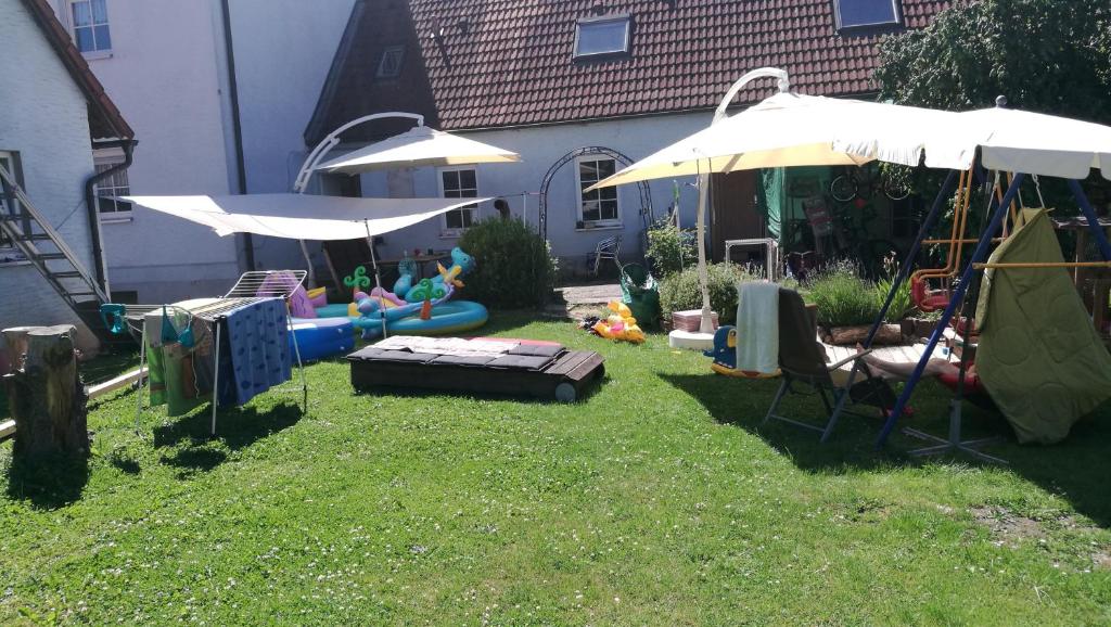 einen Hinterhof mit zwei Sonnenschirmen und einem Spielbereich in der Unterkunft Apartment Home 3 in Schwabach