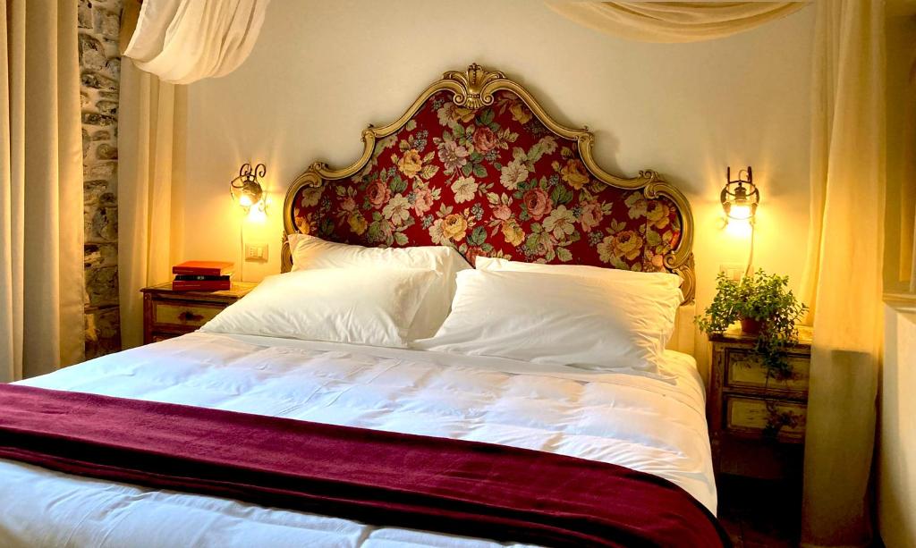a bedroom with a large bed with a floral headboard at La Corte del Governo 565 in Lezzeno