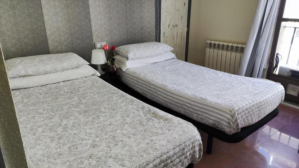 Postel nebo postele na pokoji v ubytování Hostal Romero