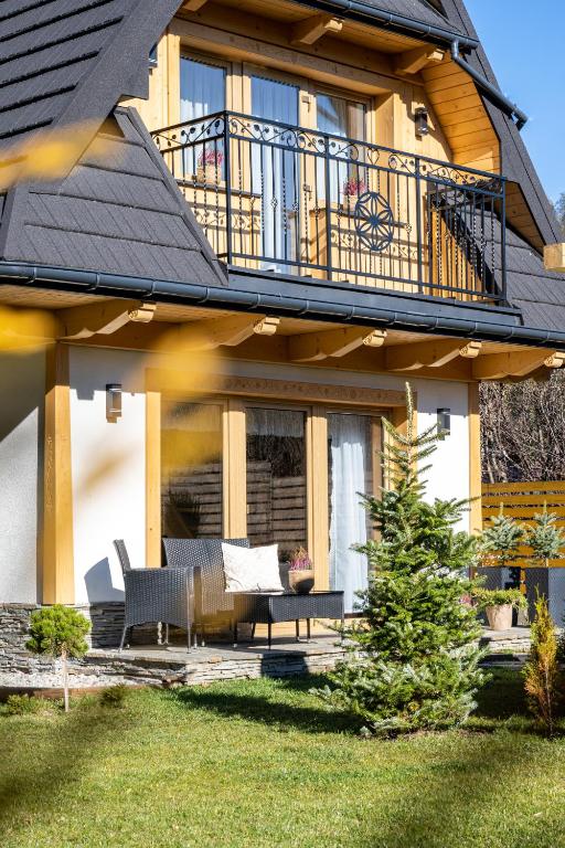 a house with a balcony and a patio at Domek Chatka Góralki in Poronin