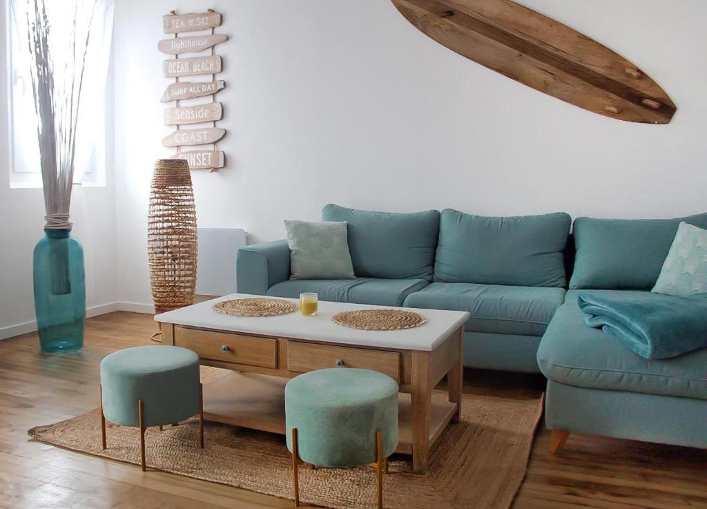 sala de estar con sofá, mesa y sillas en Le 8 ∙ Appartement cosy avec balcon vue sur mer, en Mers-les-Bains