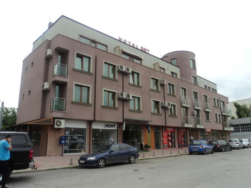 a brown building with cars parked in front of it at Hotel 007 in Sofia