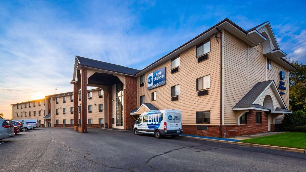 Best Western Providence Warwick Airport Inn في وارويك: سيارة فان بيضاء متوقفة أمام مبنى