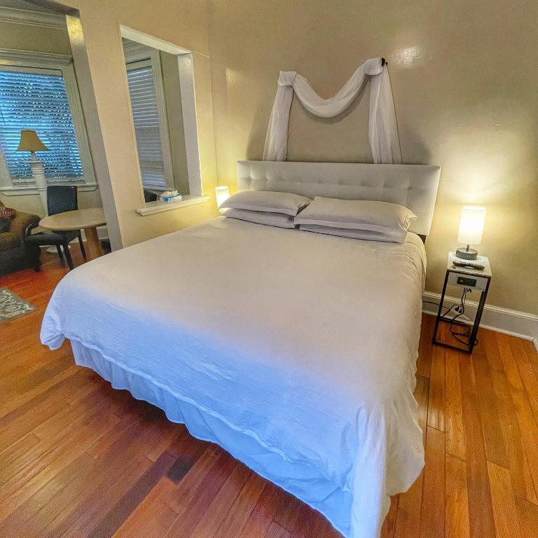 a bedroom with a large white bed with a window at The Casablanca Hotel in Key West