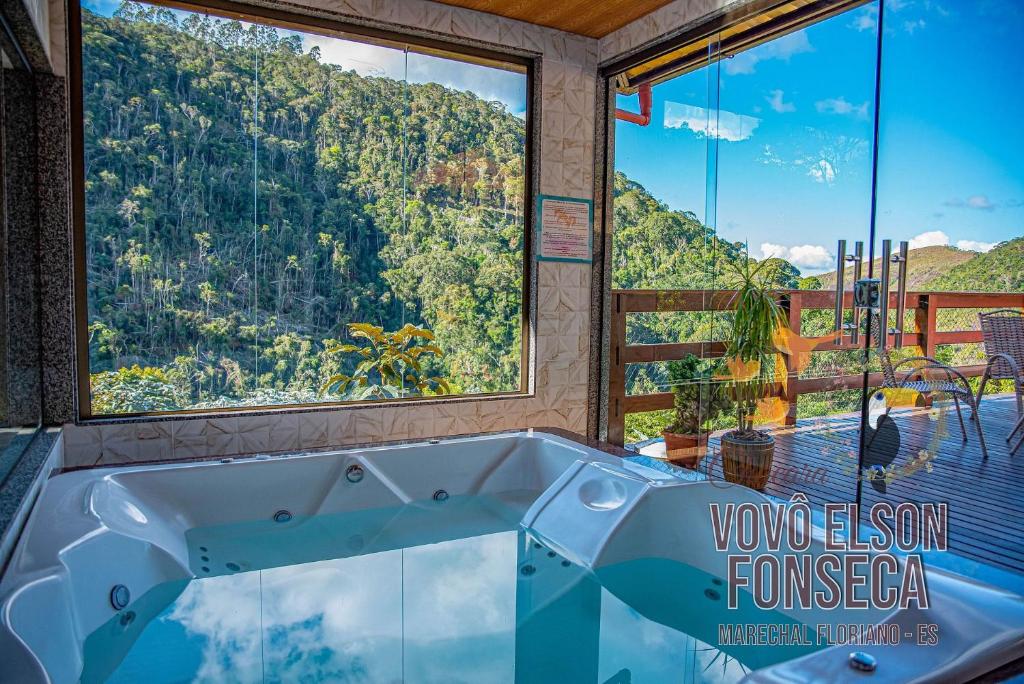 マレシャウ・フロリアノにあるChácara Vovô Elson Fonseca - um refúgio nas Montanhas Capixabasの大きな窓のある客室で、バスタブが備わります。