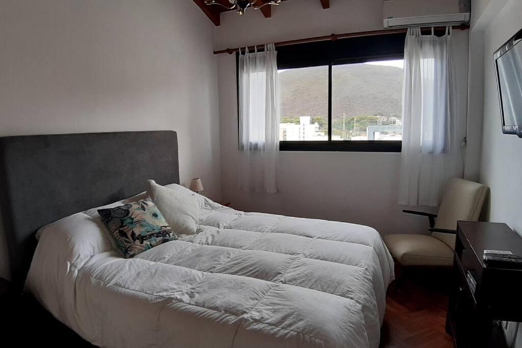 1 cama en un dormitorio con ventana en Hermoso departamento céntrico en ultimo piso, con cochera en Salta