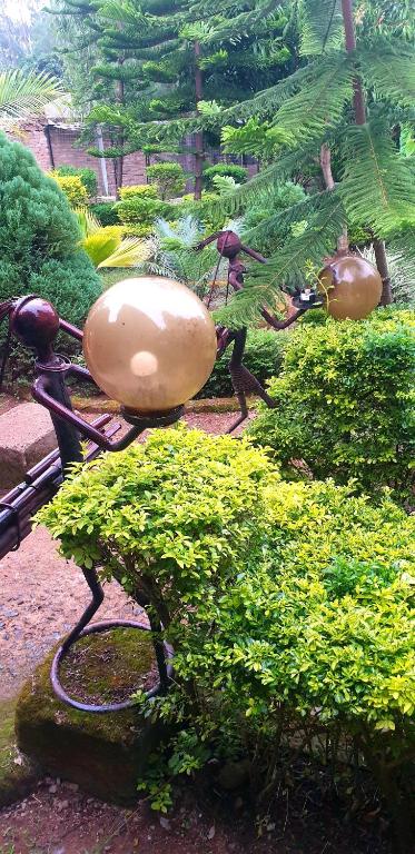 a statue of a vase on a bike in a garden at Jaaja's - The Residence, Garden and Suites near Ciala Resort Hotel Kisumu in Kisumu