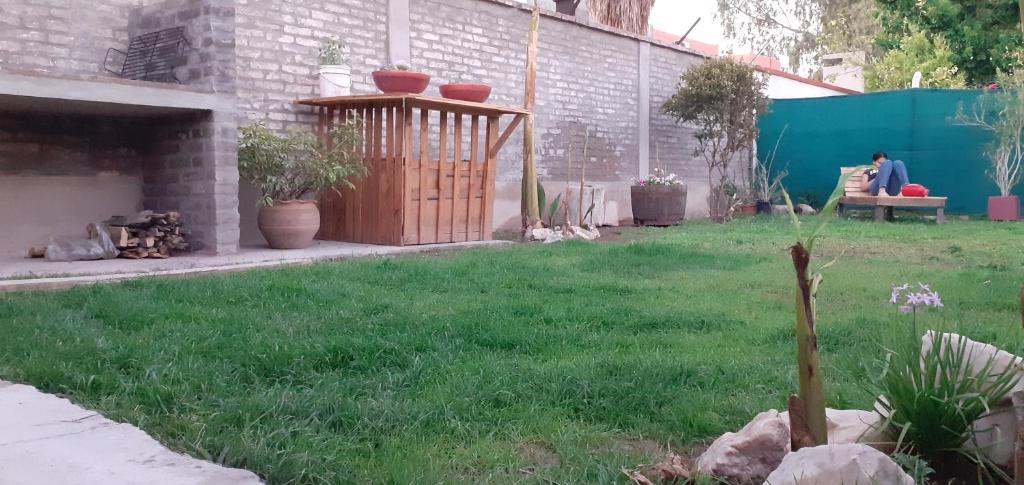 a yard with green grass and a patio with plants at OliWine hostel in Maipú