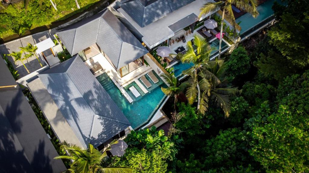 een uitzicht op een huis met een zwembad bij Villa Dua Baskom by BaliSuperHost in Ubud