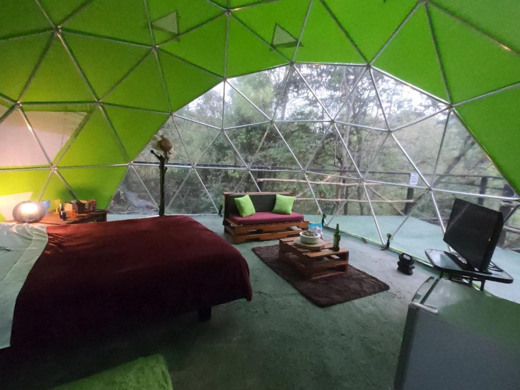 1 dormitorio con 1 tienda de campaña con 1 cama y 1 sofá en Glamping Dimensión Ecológica en Guateque