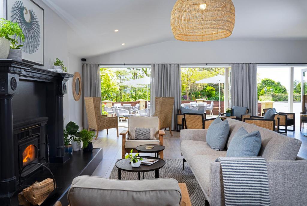 a living room with a couch and a fireplace at Ratanui Lodge in Pohara