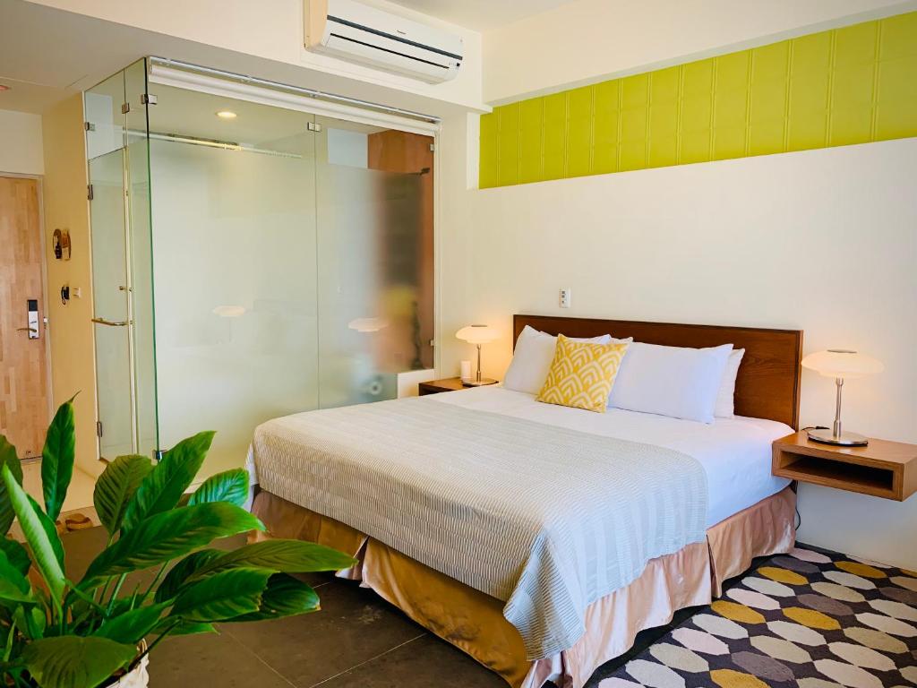a bedroom with a bed and a glass shower at The Deer Head Inn in Kenting