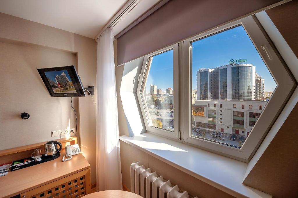a room with a window with a view of a city at AZIMUT Hotel Siberia in Novosibirsk