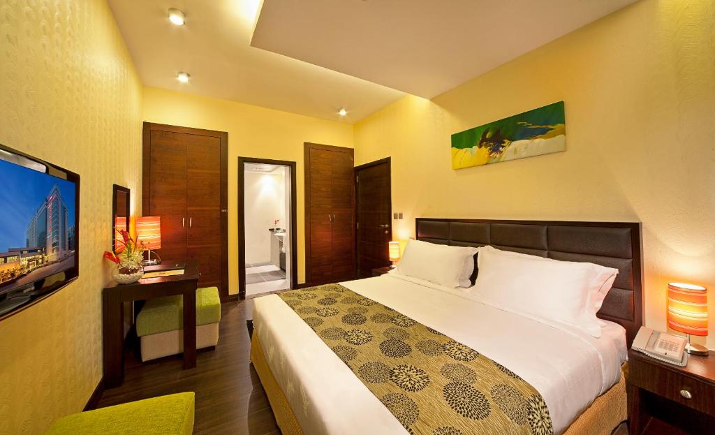 a bedroom with a large bed and a television at Marina View Deluxe Hotel Apartment in Dubai