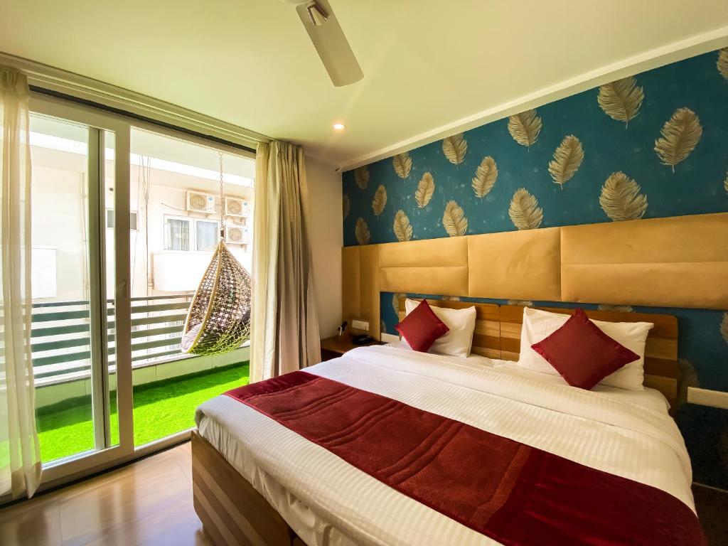 um quarto com uma cama e uma grande janela em Sky Suites em Gurgaon