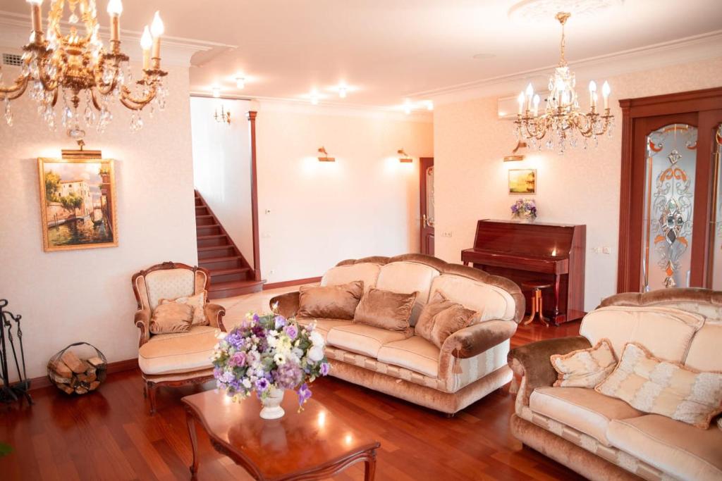 una sala de estar con 2 sofás y un piano en Villa Avoti, en Sigulda
