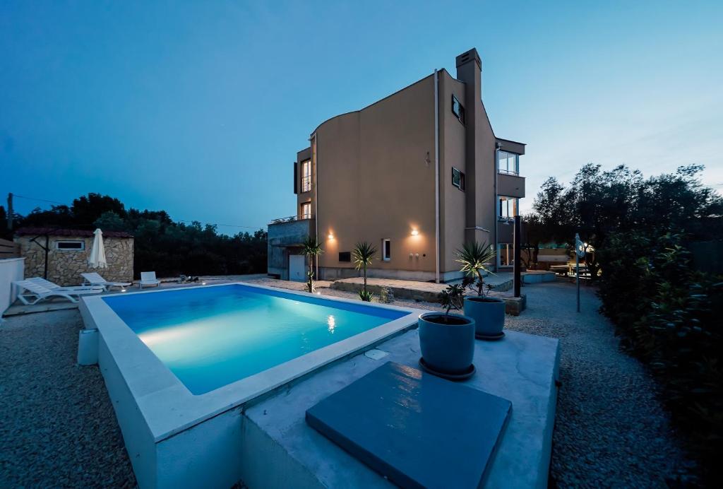 a swimming pool in front of a building at Villa Frida in Sutomišćica