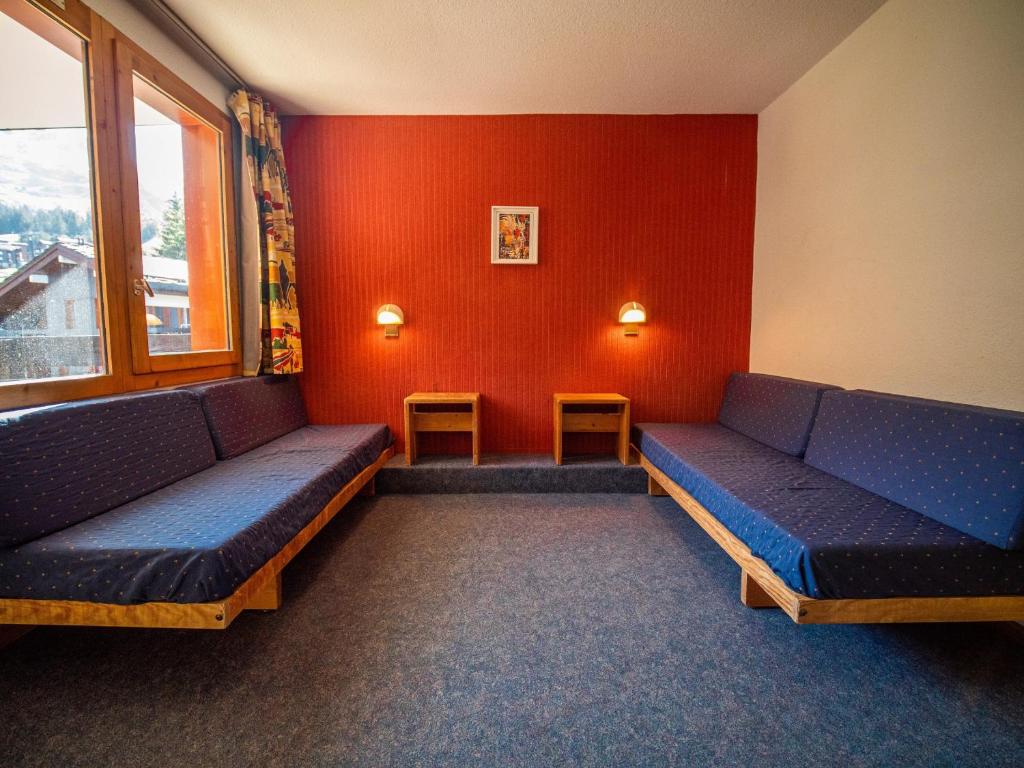 a waiting room with blue seats and a red wall at Appartement Valmorel, 1 pièce, 4 personnes - FR-1-356-254 in Valmorel