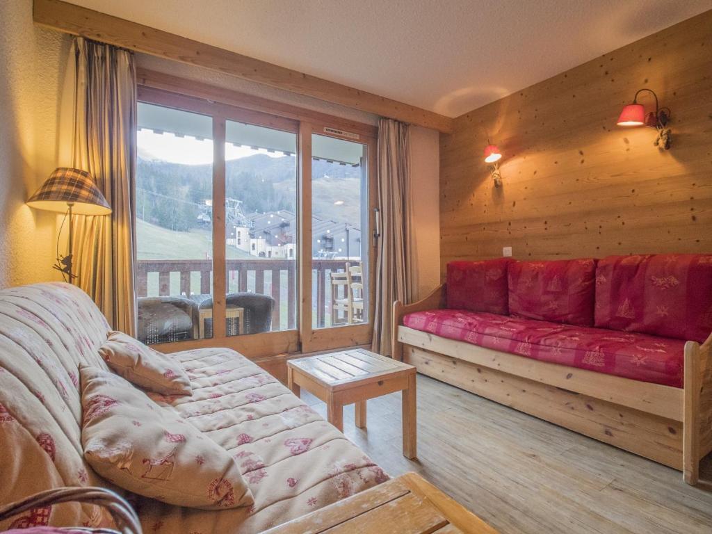 a living room with a red couch and a balcony at Appartement Valmorel, 2 pièces, 4 personnes - FR-1-356-292 in Valmorel