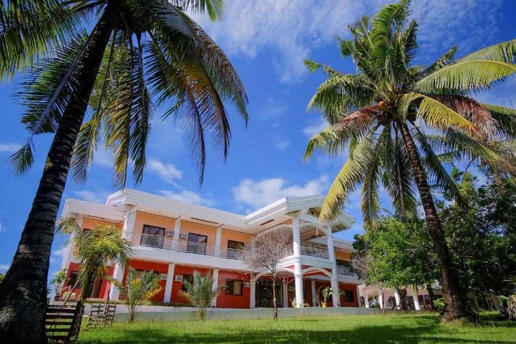 budynek z palmami przed nim w obiekcie Winter's Farm Resort w mieście Milagros