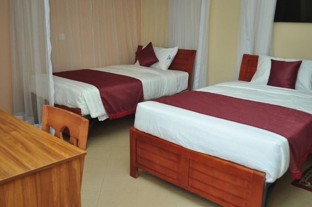 a hotel room with two beds with red and white sheets at Modern Space in Nairobi