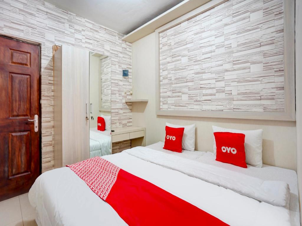 A bed or beds in a room at SUPER OYO 90606 Glass House Citraland Syariah