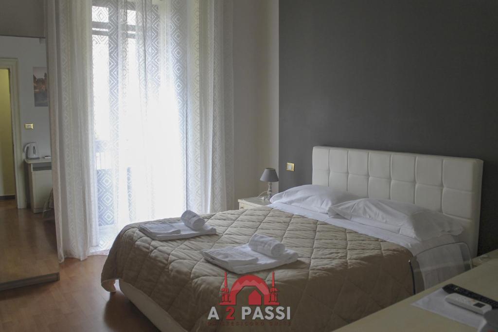 Un dormitorio con una cama grande con toallas. en A 2 Passi da Stesicoro Suite Catania, en Catania