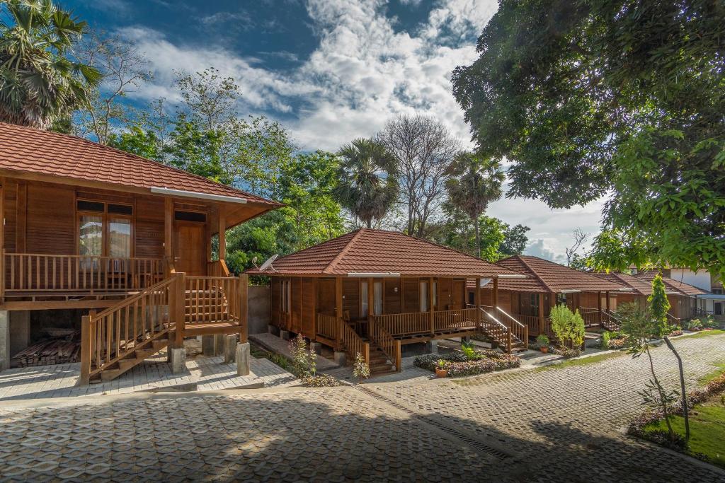 uma fila de chalés de madeira num resort em Casa Kandara em Waingapu