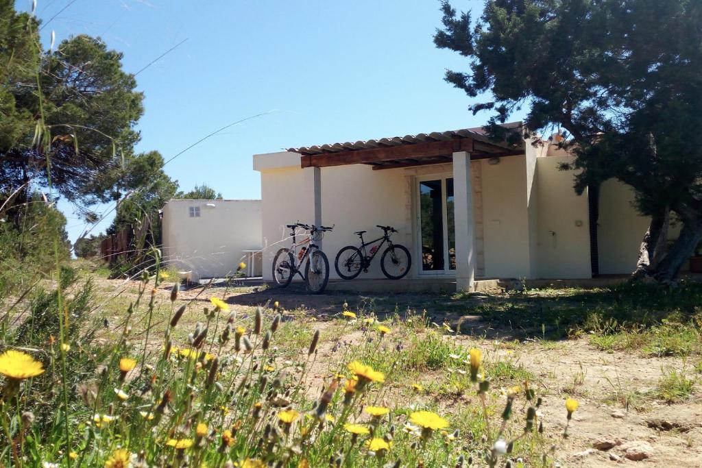 dos bicicletas estacionadas frente a un edificio en La Casita Yolanda, ideal parejas - Formentera Natural en Sant Ferran de Ses Roques