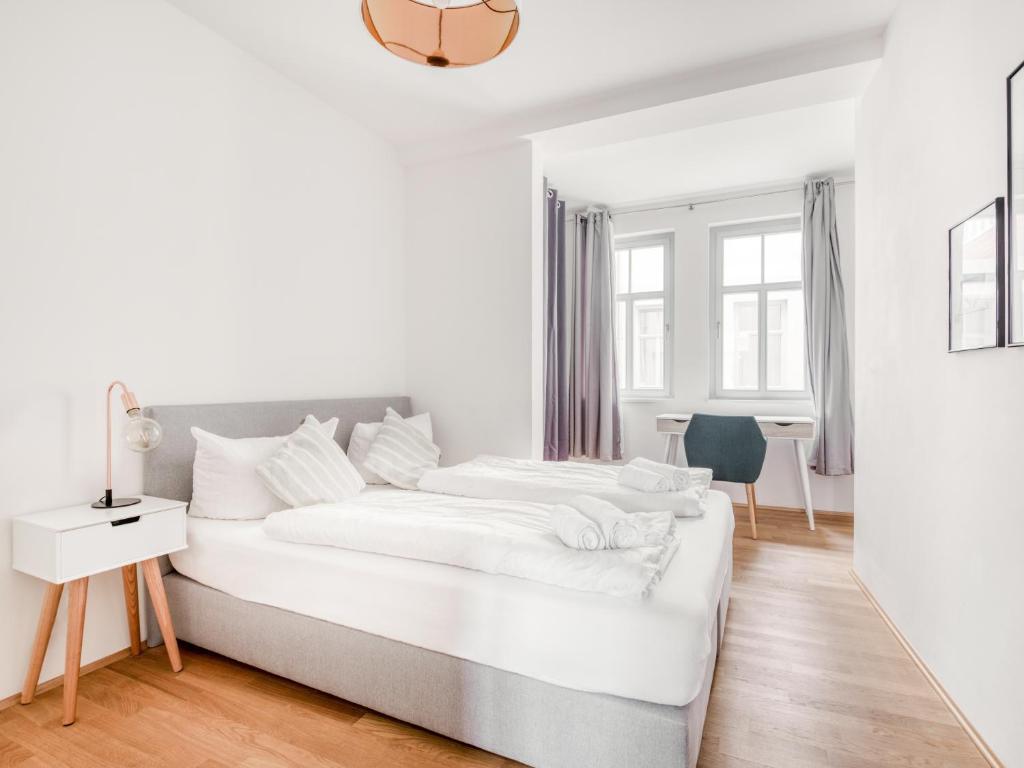エアフルトにあるLimehome Erfurt Bürgermeister-Wagner-Straßeのベッドと机のある白い寝室