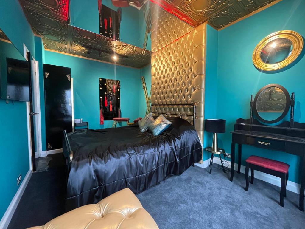 a bedroom with blue walls and a bed and a mirror at Boutique Dungeon in Brighton & Hove
