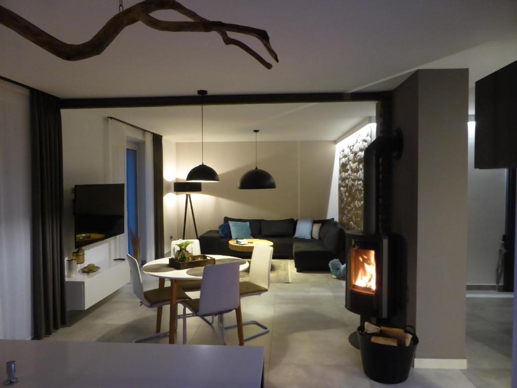 salon ze stołem i kominkiem w obiekcie Apartament Premium Moszna w Mosznej