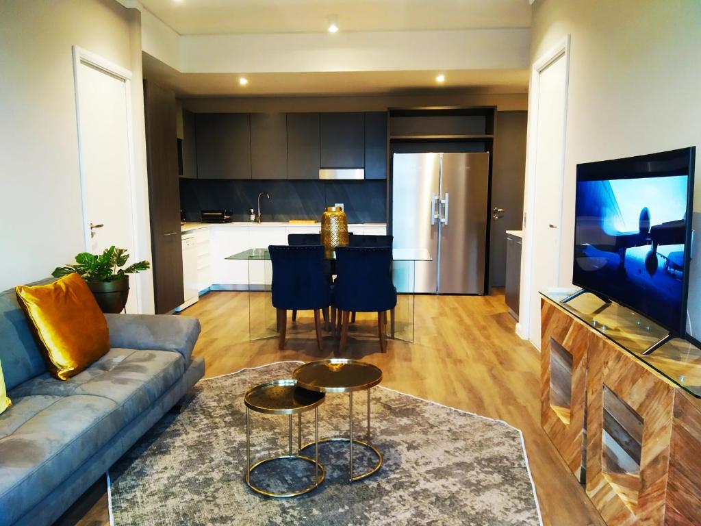 a living room with a couch and a kitchen at Menlyn Residence - Luxury Business Apartment in Pretoria